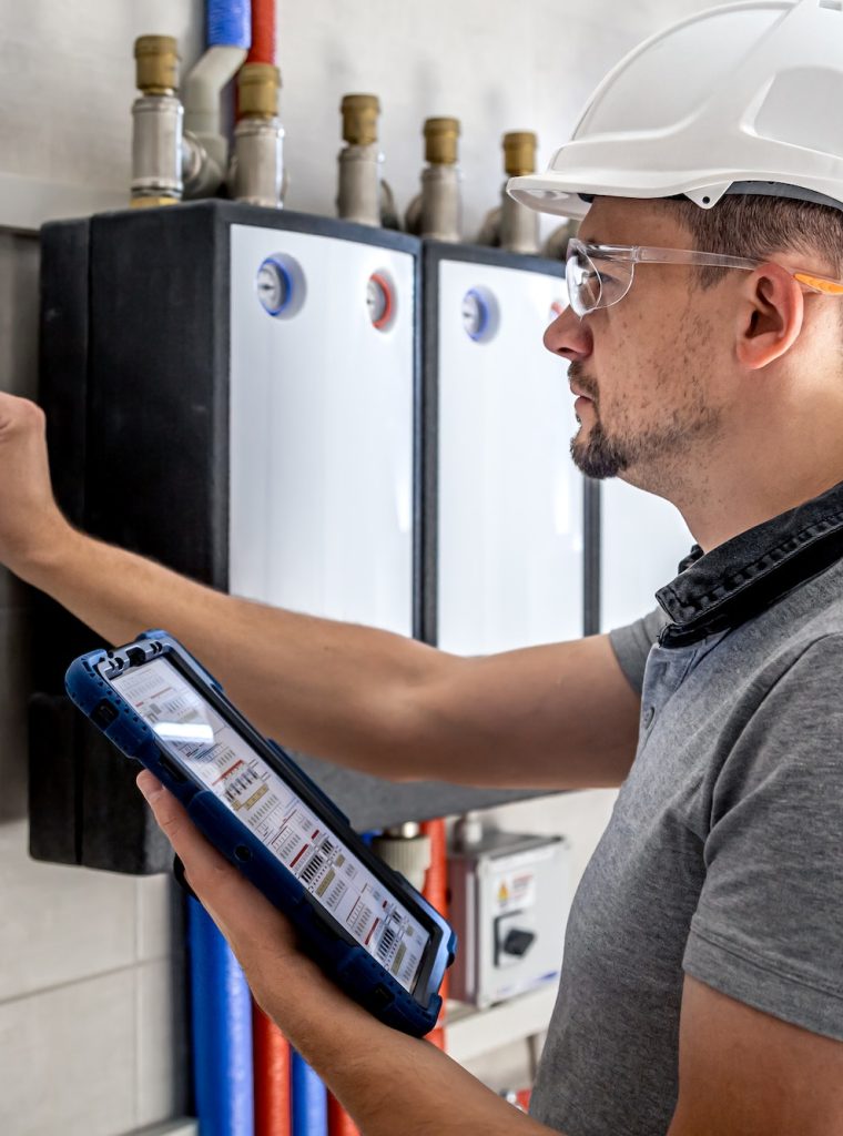 Electrical technician looking focused while working in a switchboard with fuses.