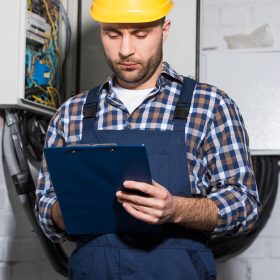 Electrician filling checklist of power line maintenance