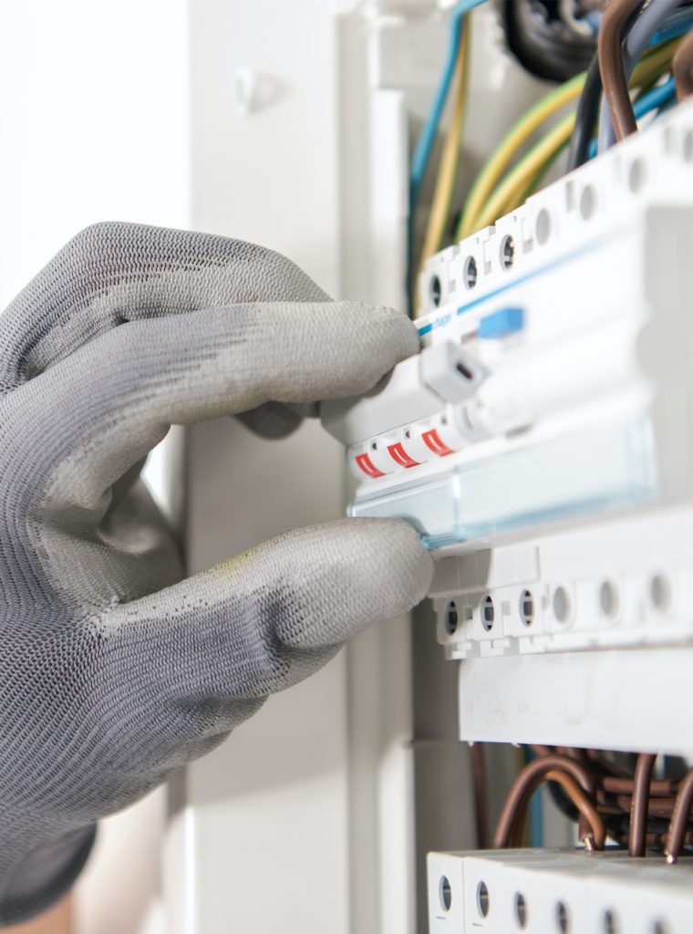Electrician Testing Fuses In the Electric Box